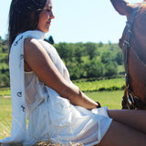 Foulard mors blanc une cavalière sur un balleau de paille tenant son cheval au licol. Ce foulard est très légé et parfait pour la mi saison 